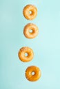 Various decorated donuts in motion falling on a blue background. Sweet and iced donuts fall or fly in motion. With coconut flakes Royalty Free Stock Photo