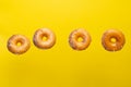 Various decorated donuts in motion falling on a yellow background. Sweet and iced donuts. With pieces of chocolate. Horizontal. Royalty Free Stock Photo