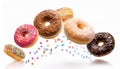 Various decorated doughnuts in motion falling on white background Royalty Free Stock Photo