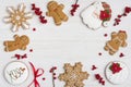 Various decorated gingerbread cookies and holly berries on wooden background