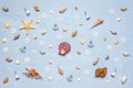 Various decorative nautical items, seashells, sea stars and miniature toys on blue pastel background. Sea travel, summer vacation