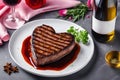 Various degrees of doneness of heart-shaped beef steak with spices white plate and a glass of wine dark stone background