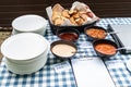 Various dip sauces on black bowls with white plates on dinner table setting Royalty Free Stock Photo