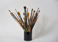 Various dirty paint brushes in a black cup isolated on white Royalty Free Stock Photo