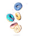 Various donuts with motley glaze in the air on a white background
