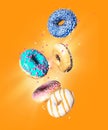 Various donuts with motley glaze in the air on a yellow background