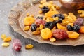 Various dried fruits on toreutic plate over stone background