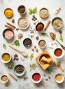 Various dry spices in small bowls and raw herbs flat lay on grey background Royalty Free Stock Photo