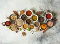 Various dry spices in small bowls and raw herbs flat lay on grey background Royalty Free Stock Photo