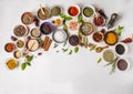 Various dry spices in small bowls and raw herbs flat lay on white background. Top view Royalty Free Stock Photo