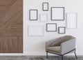 Various empty picture frames on white wall in modern room. Mock up interior in contemporary style. Free, copy space for