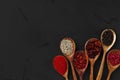 Various exotic spices in wooden spoons on dark background