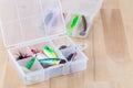 Various fishing accessories in plastic box on wooden background, horizontal, copy space Royalty Free Stock Photo