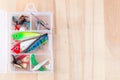 Various fishing lures in plastic box on wooden background, horizontal, top view, copy space Royalty Free Stock Photo