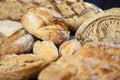 Various French breads, such as baguette, petits pains and loafs of sourdough, called pain de campagne, on display on a table.