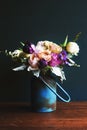 Various fresh flowers arrangement in metallic vase on wooden tabl Royalty Free Stock Photo