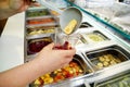 Various fresh fruit and vegetable salad bar healthy items. Hand is preparing fruits for organic smoothie. Royalty Free Stock Photo