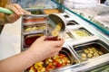 Various fresh fruit and vegetable salad bar healthy items. Hand is preparing fruits for organic smoothie. Royalty Free Stock Photo