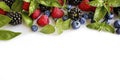 Various fresh summer berries on white background. Ripe raspberries, blackberries, blueberries, mint and basil leaves. Royalty Free Stock Photo