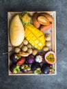 Various fresh Thai fruits - rambutan, mango, mangosteen, longan, sapodilla, passion fruit, salak, on a wooden tray and a gray Royalty Free Stock Photo