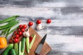 Various fresh vegetables with cutting board on wooden background Royalty Free Stock Photo