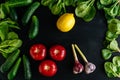 Various fresh vegetables organic food for healthy eating on dark background. Cucumbers Tomatoes Garlic Lemon Spinach. Royalty Free Stock Photo