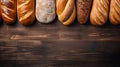 Various freshly baked bread displayed on wooden surface, top view with empty space Royalty Free Stock Photo