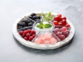 various frozen fruits in five compartment plate on white marble table. served with elegance