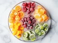 various frozen fruits in five compartment plate on white marble table. served with elegance