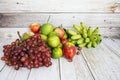 Various of fruits with Red grape, red apple, banana and green orange on wooden background Royalty Free Stock Photo