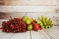 Various of fruits with Red grape, red apple, banana and green orange on wooden background Royalty Free Stock Photo