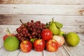 Red grape, red apple and green orange with space copy on wooden background Royalty Free Stock Photo