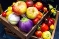 Various fruits and vegetables in wooden boxes top view. Ripe apples, tomatoes, peppers, various eggplants. Fresh fruits and