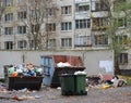Various garbage containers full of garbage are located in the courtyard of an apartment building Royalty Free Stock Photo