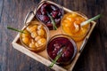 Various glass bowl of Fruit jams Apricot, cherry, strawberry, damson plum in wooden tray. Royalty Free Stock Photo