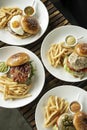 Various gourmet burgers selection on restaurant wood table