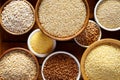 Various groats, cereals. Different types of groats in bowls on a wooden background, top view, close up.