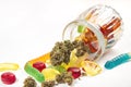 Various gummies and dried medical marijuana buds fell out of the embossed glass jar.