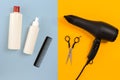 Various hair styling devices on the color blue, yellow paper background, top view Royalty Free Stock Photo