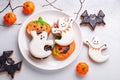 Various Halloween gingerbread cookies on white plate on stone background. Bright homemade cookies for Halloween party