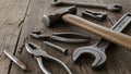Various hand tools are arranged on a rustic wooden surface. A hammer with a wooden handle and Royalty Free Stock Photo