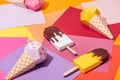 Various handmade origami ice cream on multicolored paper.