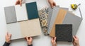 Various hands holding diverse interior design material samples including textures and patterns for home renovation inspiration Royalty Free Stock Photo