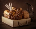Various homemade bread in rustic wooden box with ears of wheat. Royalty Free Stock Photo