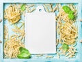 Various homemade fresh uncooked Italian pasta and white ceramic board Royalty Free Stock Photo