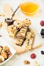 Various homemade granola bars with nuts, seeds, dark chocolate, honey and berries over a wooden board Royalty Free Stock Photo