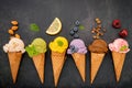 Various of ice cream flavor in cones blueberry ,green tea ,pistachio ,almond ,orange and cherry setup on dark stone background . Royalty Free Stock Photo