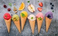 Various of ice cream flavor in cones blueberry ,green tea ,pistachio ,almond ,orange and cherry setup on dark stone background . Royalty Free Stock Photo