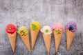 Various of ice cream flavor in cones blueberry ,green tea ,pistachio ,almond ,orange and cherry setup on dark stone background . Royalty Free Stock Photo