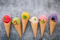 Various of ice cream flavor in cones blueberry ,green tea ,pistachio ,almond ,orange and cherry setup on dark stone background . Royalty Free Stock Photo